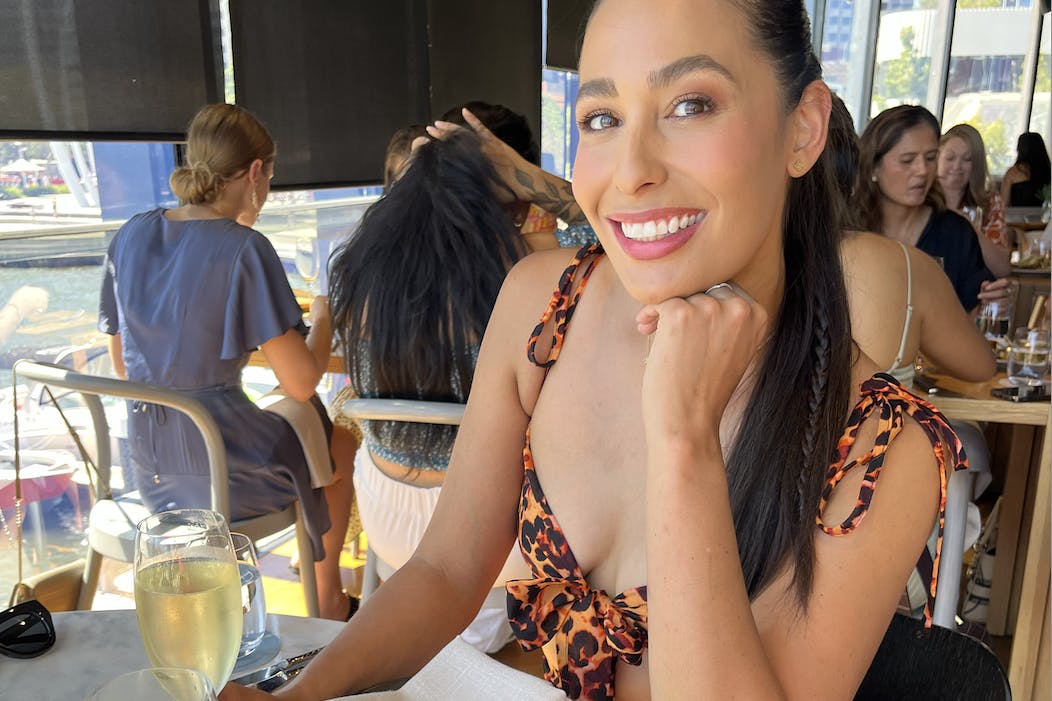 Woman sitting at a long lunch with wine.